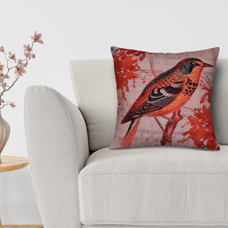 Bird-pattern pillow cover on beige armchair with red orange bird on pale fabric