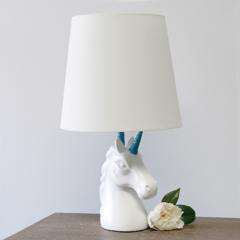 White unicorn table lamp with white fabric shade, blue glitter horn, flower accent