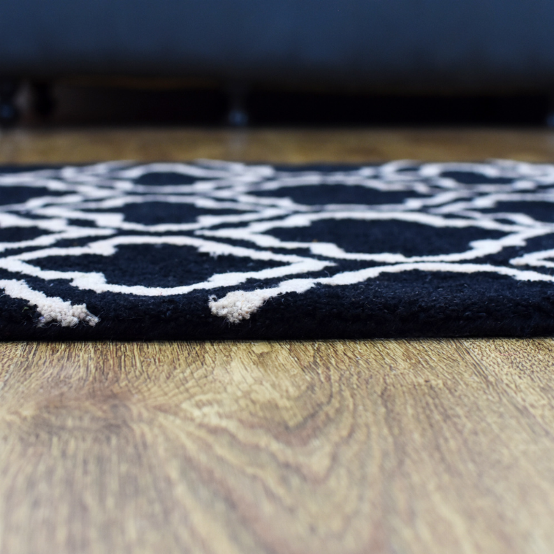 Black geometric wool runner rug with ivory quatrefoil trellis pattern.