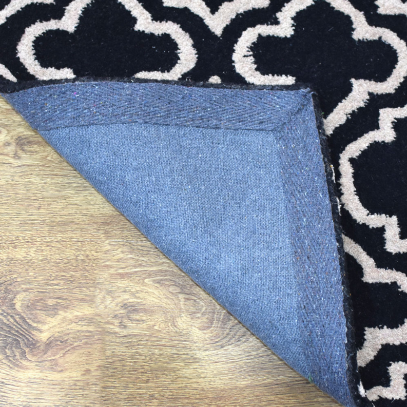 Runner rug corner showing navy geometric pattern and textured backing