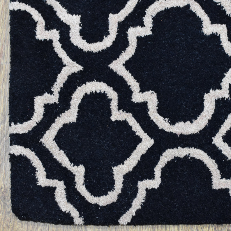 Hand-tufted wool runner rug close-up of navy and white quatrefoil pattern