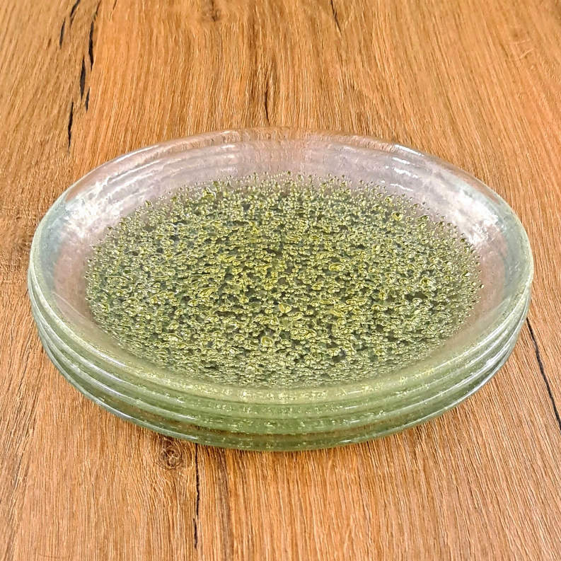 Glass dinner plate with green-gold speckled interior and clear outer rim, stacked.