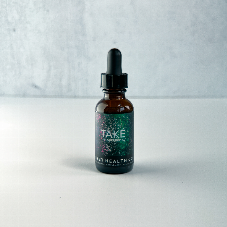 Amber glass dropper bottle with black cap and TAKE label, angled view on counter.