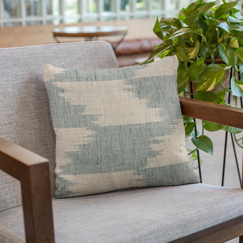 Faded abstract blue-and-cream throw pillow with horizontal stripe blocks on seat.