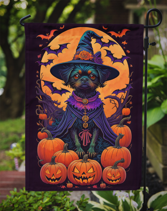 Witchy dog garden flag on a stake with bats and pumpkins beside green plants