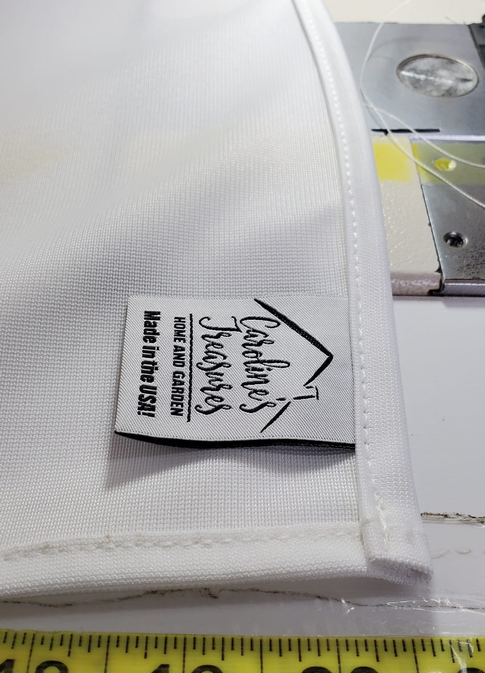 White stitched fabric label on a house flag edge with care instructions