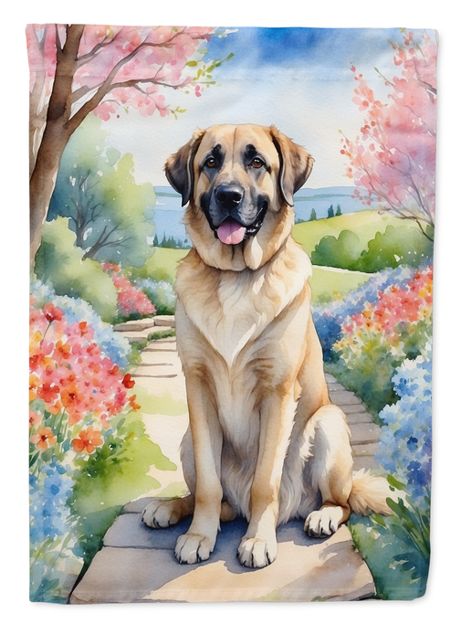 Garden flag with seated tan-and-black dog on a path with spring flowers