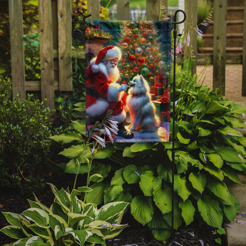 Garden flag showing Santa kneeling and a white-furred child beside gift boxes