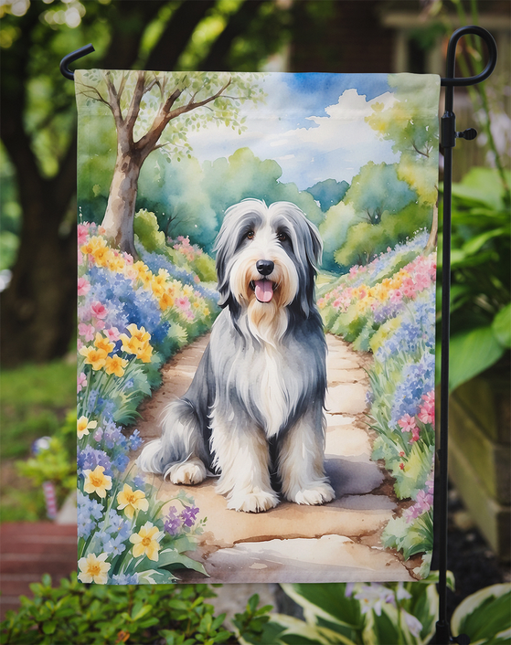 Bearded collie spring garden flag on a yard pole, flowers and winding path
