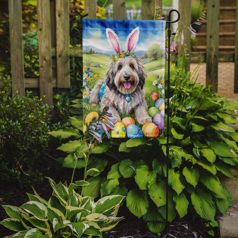 Easter garden flag on a stake showing a sheepdog among Easter eggs and flowers
