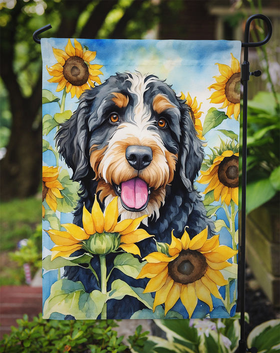 Garden flag close-up: Bernedoodle dog portrait surrounded by yellow sunflowers