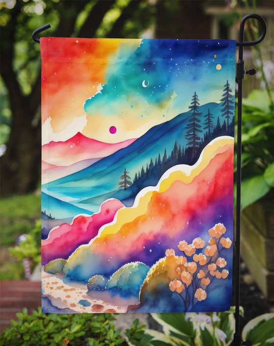 Colorful garden flag on a yard stake, watercolor mountain and pine tree scene
