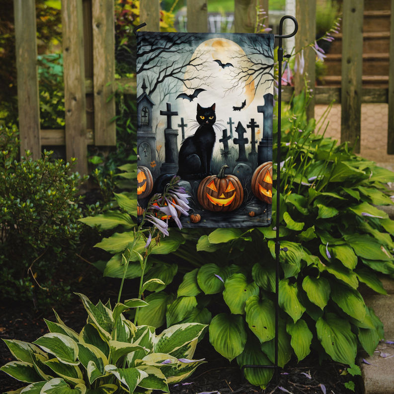 Halloween garden flag standing outdoors with black cat, graveyard, bats, and pumpkins