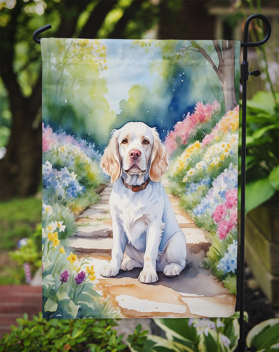 Garden flag close-up of golden retriever framed by spring flowers and garden path