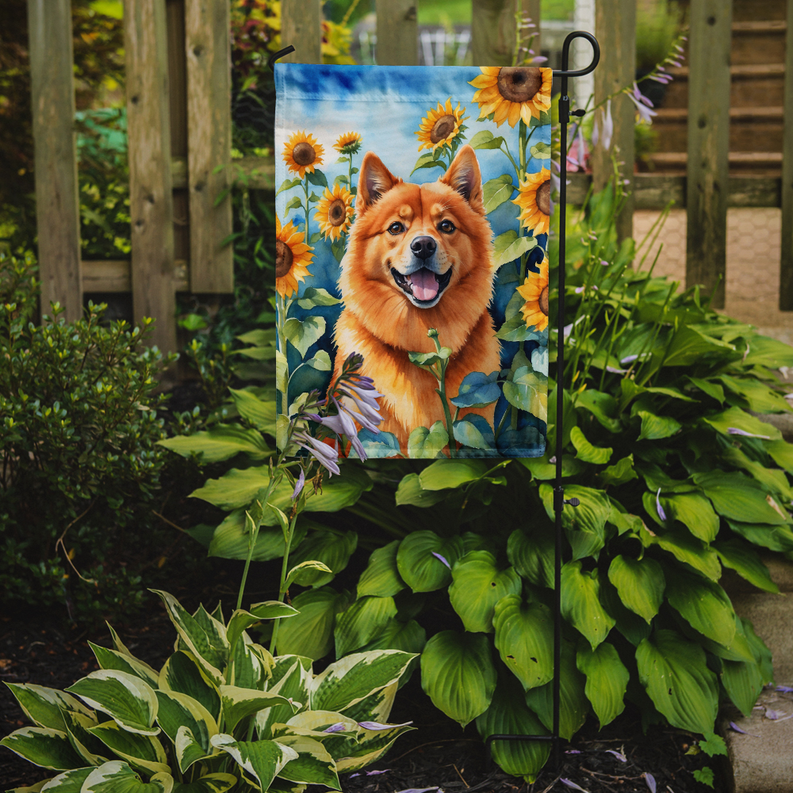 Outdoor garden flag showing an orange Finnish Spitz with sunflowers and green leaves on a stake.
