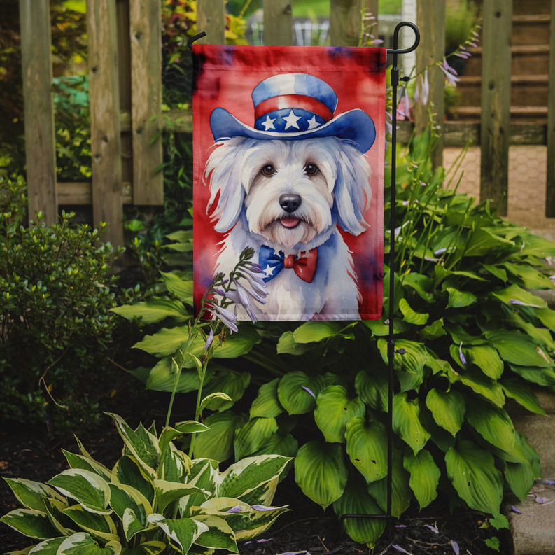 Patriotic Coton de Tulear garden flag hanging on a metal stand in a yard