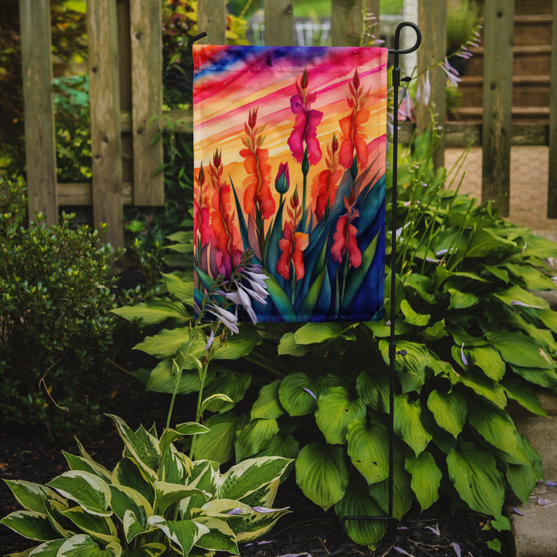 Garden flag with colorful gladiolus print, displayed on a garden stake