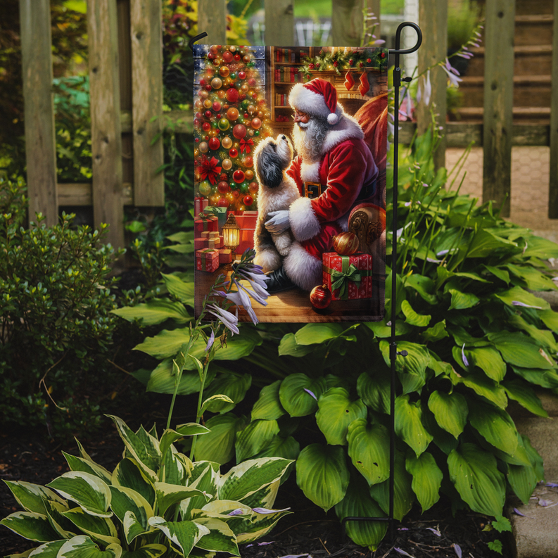 Garden flag on outdoor stake showing Santa in red holding a white Havanese dog