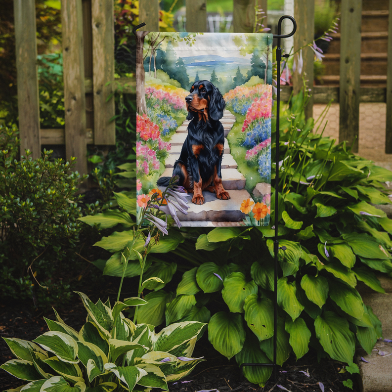 Garden flag with Gordon setter on stone walkway, displayed on two metal stakes