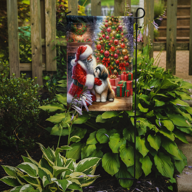 Christmas garden flag on outdoor stake with Santa and Lhasa Apso by tree