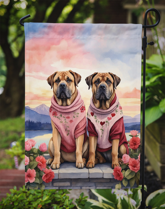 Two-mastiff garden flag in pink scarves with floral border, hanging on outdoor stand