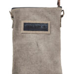Small crossbody bag with top label patch on gray canvas back panel.