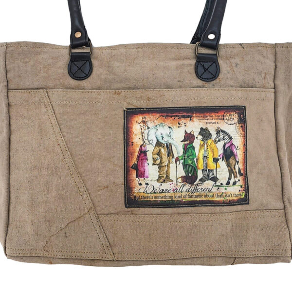 Recycled military tent shoulder bag close-up with illustrated front patch and stitched seams