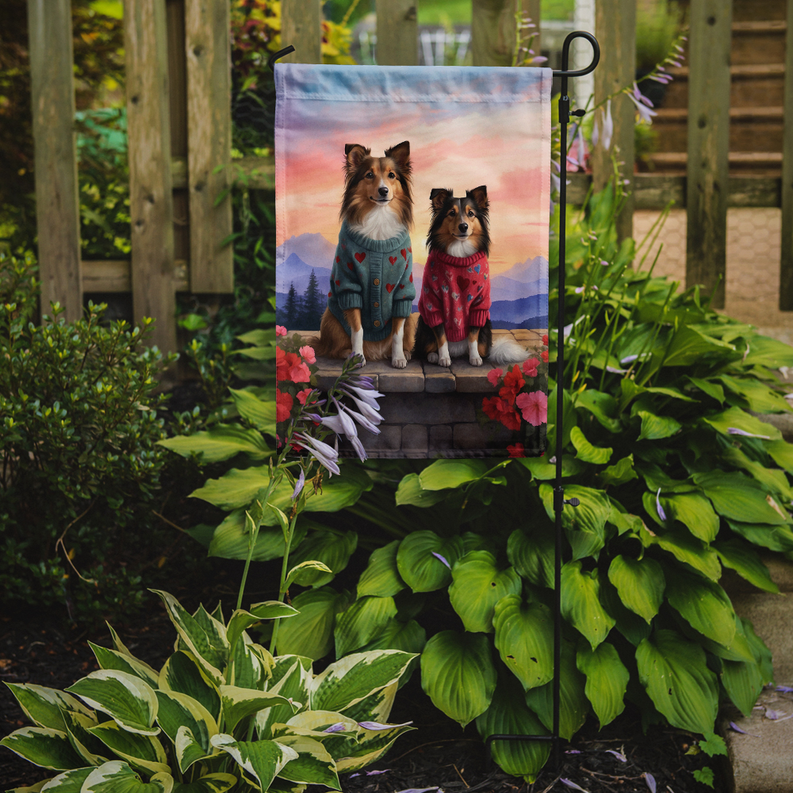 Garden flag on a stake showing two shelties in heart sweaters on stone steps