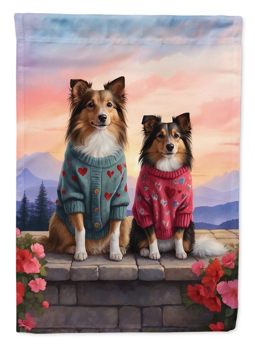 Garden flag featuring two shelties in blue and red heart sweaters on stone steps