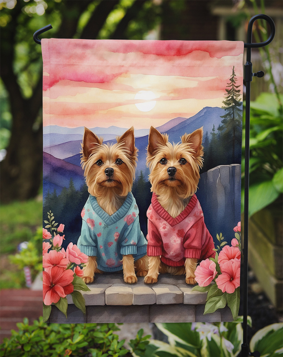 Garden flag featuring two terriers in blue and pink sweaters on a garden stone