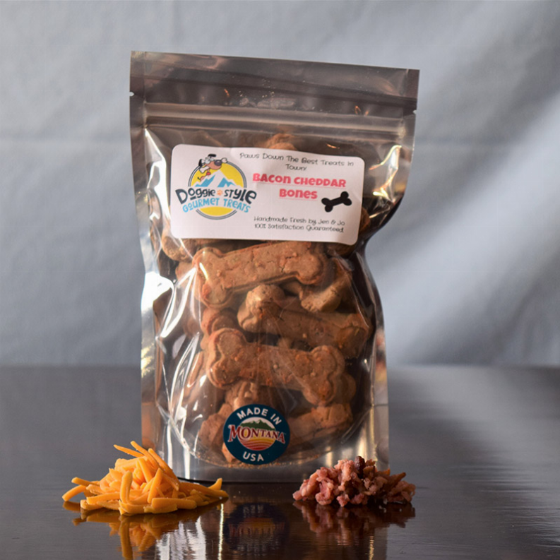 Dog treat bag of bacon cheddar flavored bones, visible brown bone-shaped treats