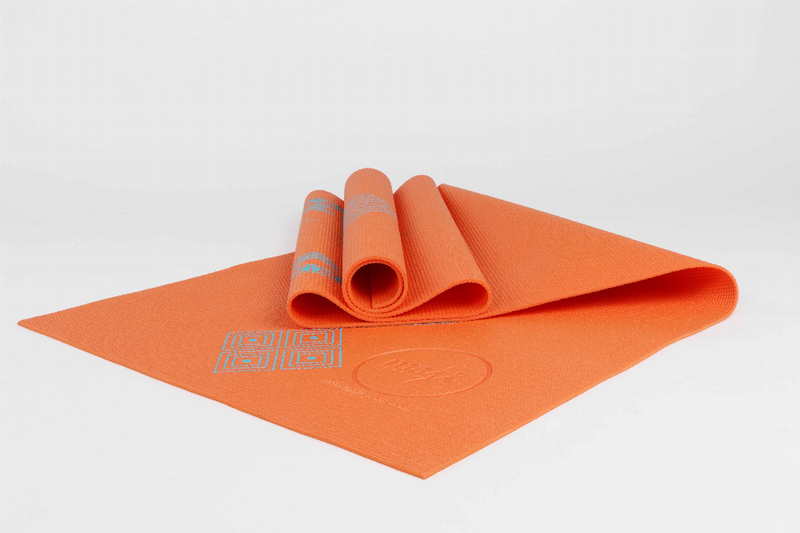 Orange printed PVC yoga mat, folded with rolled end and circular grip pattern