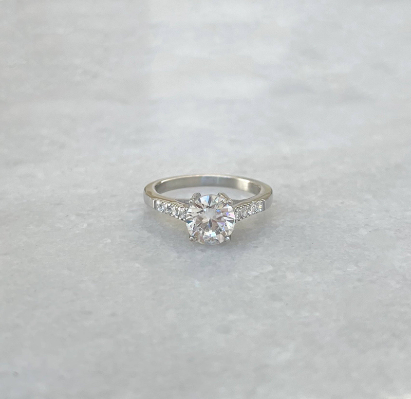 Silver promise ring with round center stone and pavé side stones