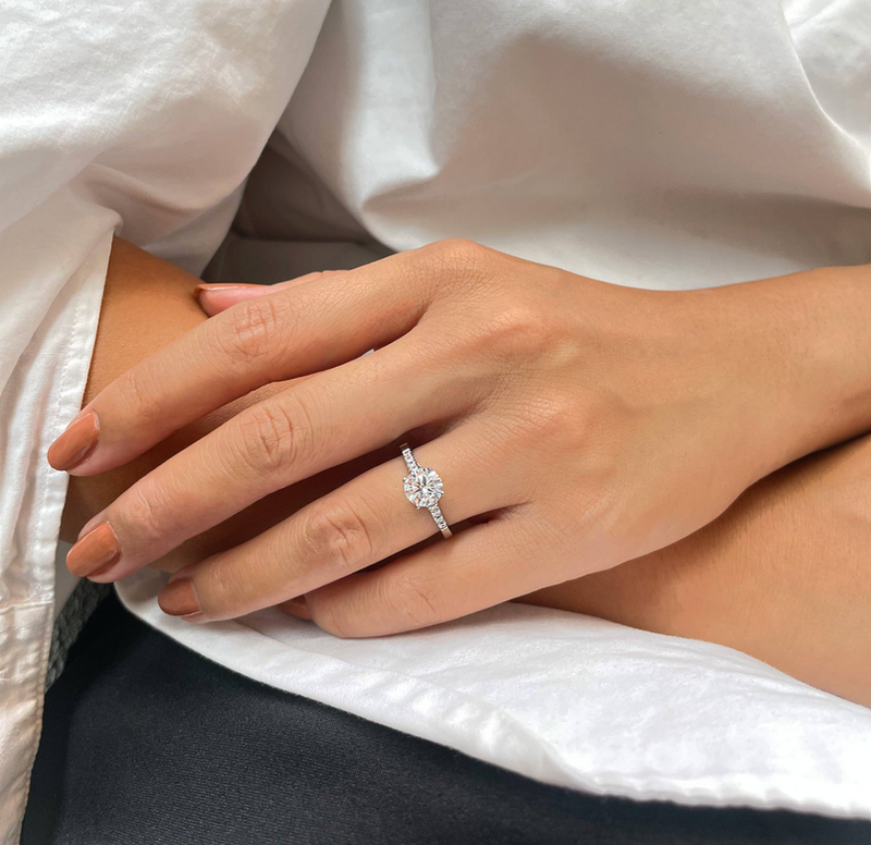 YVE promise ring on hand with round halo setting and pavé band