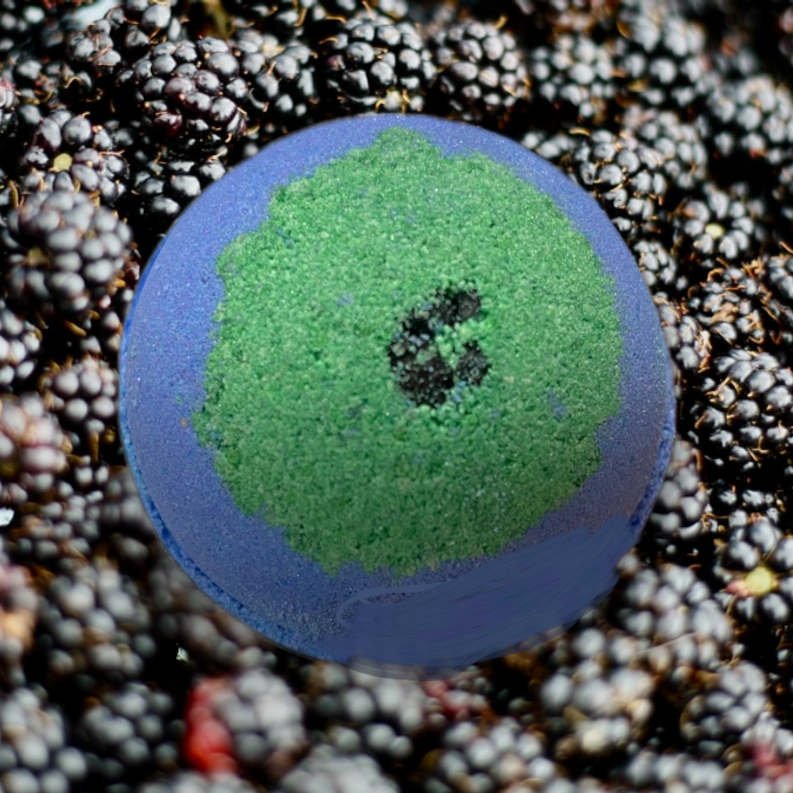 Blue bath bomb with vivid green center and dark speckle dot
