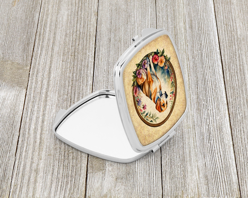 Silver compact mirror case open, showing dog-and-flower design on the mirror face