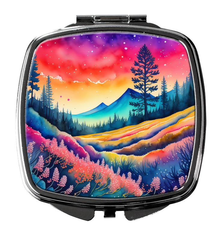 Compact mirror with silver frame and colorful mountain landscape scene on front.