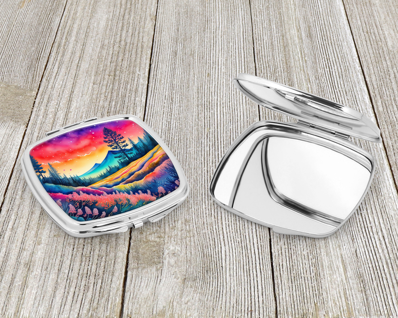 Compact mirror case with open lid; silver frame and colorful sunset mountain artwork.