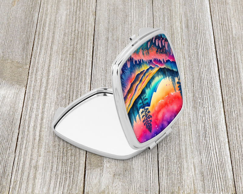 Compact mirror with open lid, silver frame, vibrant mountain and sky design.