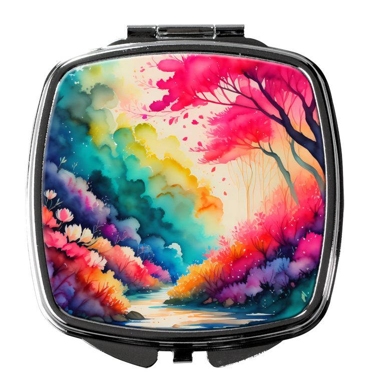 Round-edged compact mirror with colorful floral landscape print on front cover
