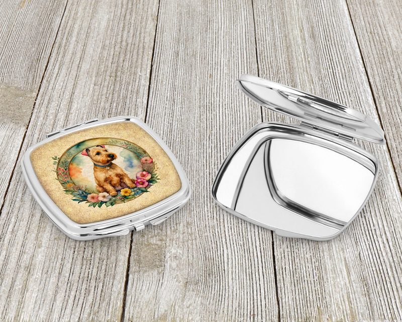 Compact mirror open with hinged silver case; terrier-and-flowers design on the lid