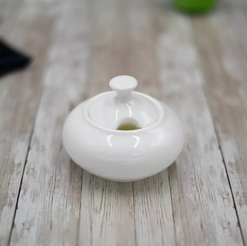 White ceramic sugar bowl with lid knob and open central opening