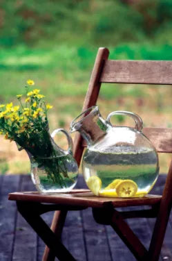 Small green glass tilted pitcher with round handle and short spout