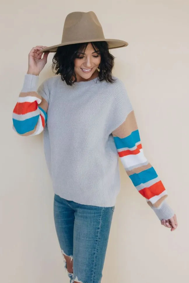 Light gray crewneck knit sweater with multicolor striped sleeves