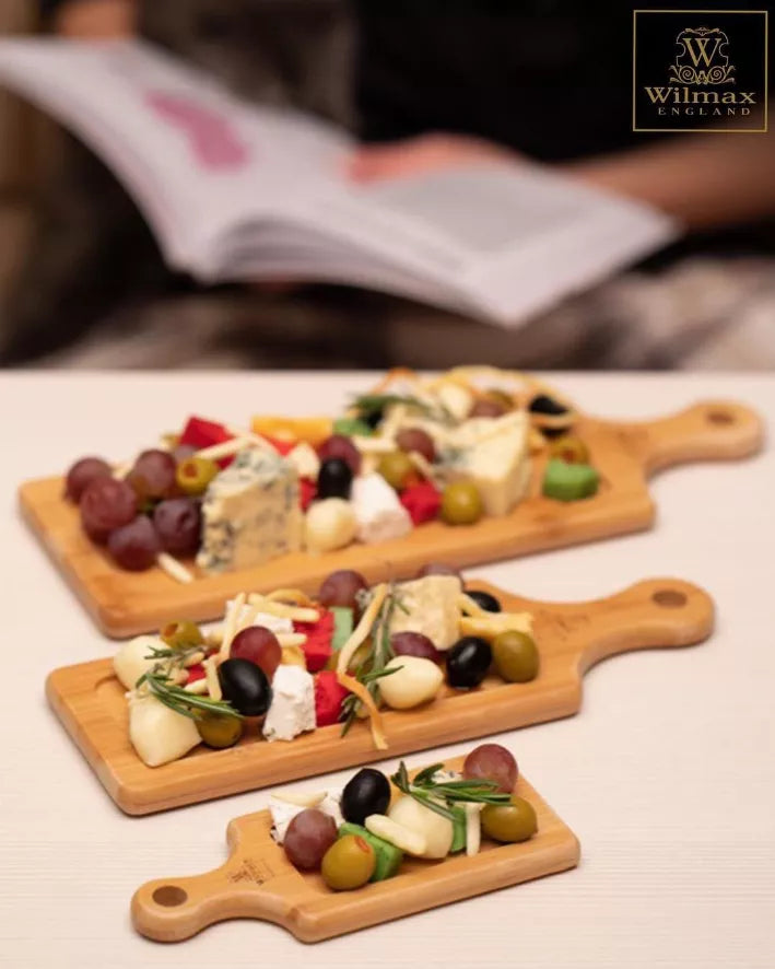 Set of wooden serving trays with handle loops, arranged with appetizers on boards