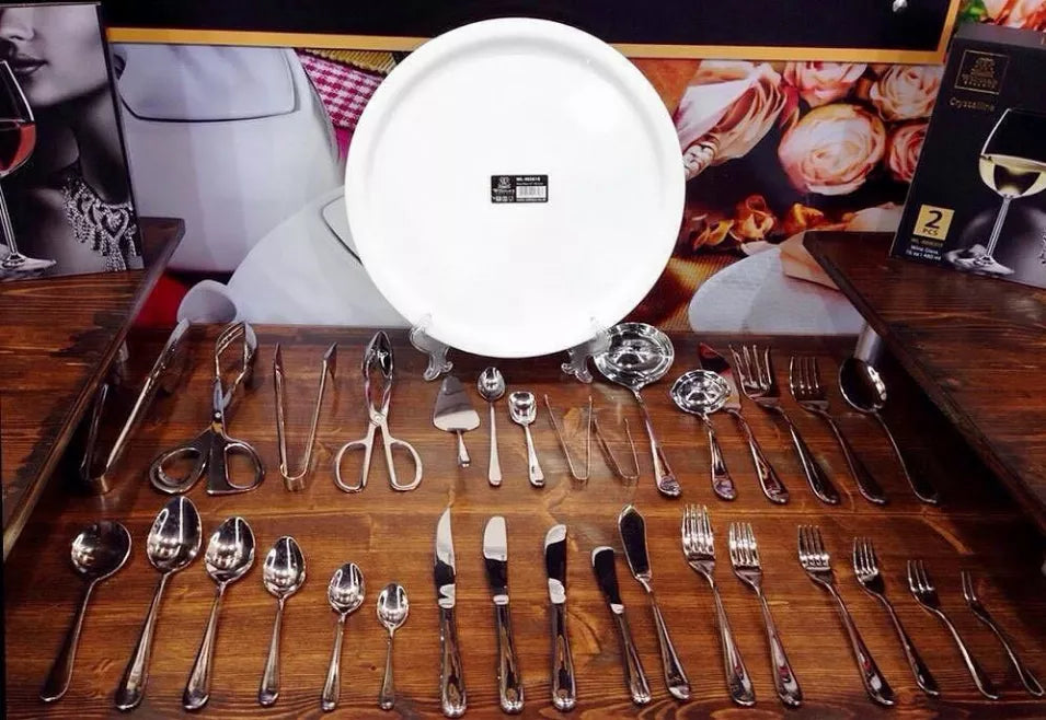 Stainless steel steak knife set of 6 with polished handles, laid out on a table.