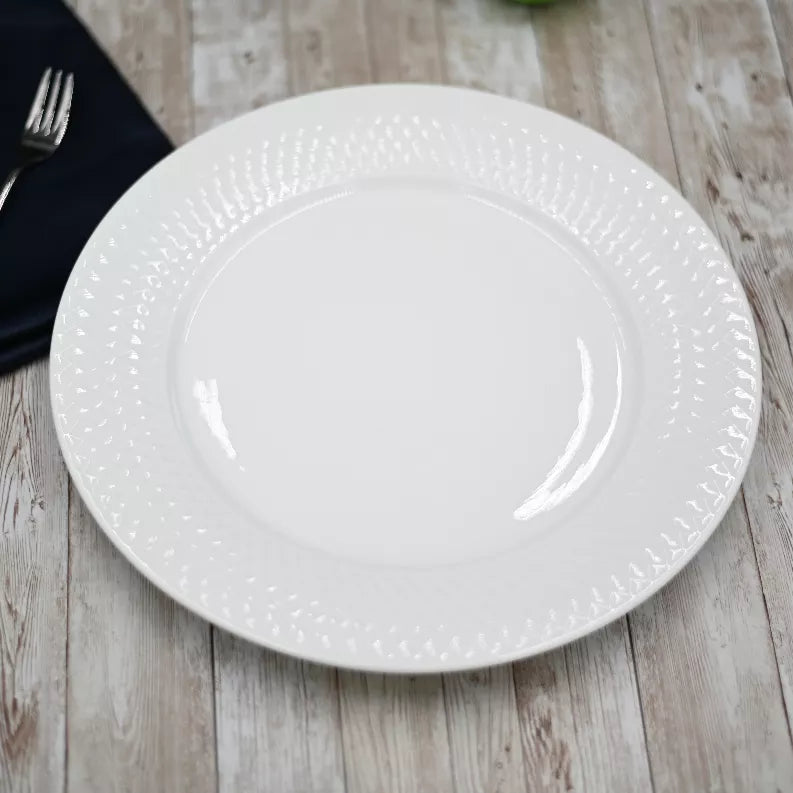 White embossed dinner plate with textured rim, empty and ready to serve