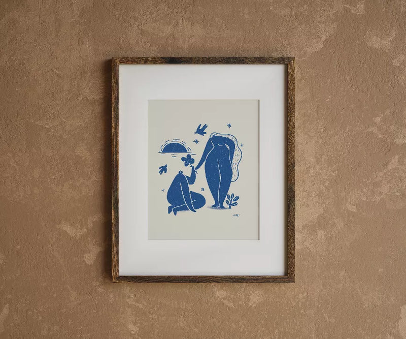 Framed illustrated art print with blue couple silhouettes facing each other on a white mat