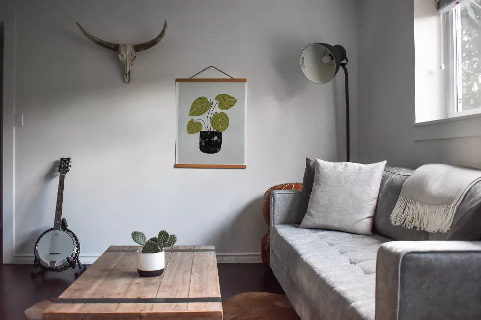 Framed peperomia wall art print hanging on wall above a sofa