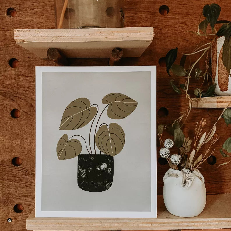 Framed peperomia wall art print with muted green leaves in black pot